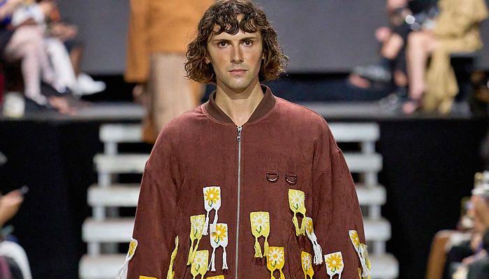 Rolf Ekroth 2025 Spring Summer Mens Runway Collection - Copenhagen Fashion Week Denmark CPHFW København - Lavatanssit - Patchwork Plaid Check Stripes Blazer Jacket Oversized Coat Corduroy Rings Scarf Hood Capelet Crochet Knit Mesh Pendants Fringes Sweater Jumper Cardigan Shorts Manskirt Denim Jeans Knee Panels Camouflage Topographic Wave Map Anorak Windbreaker Wide Leg Tearaway Pants Life Vest Quilted Puffer Padded Straps Belts Flowers Floral Puma Speedcats Sneakers